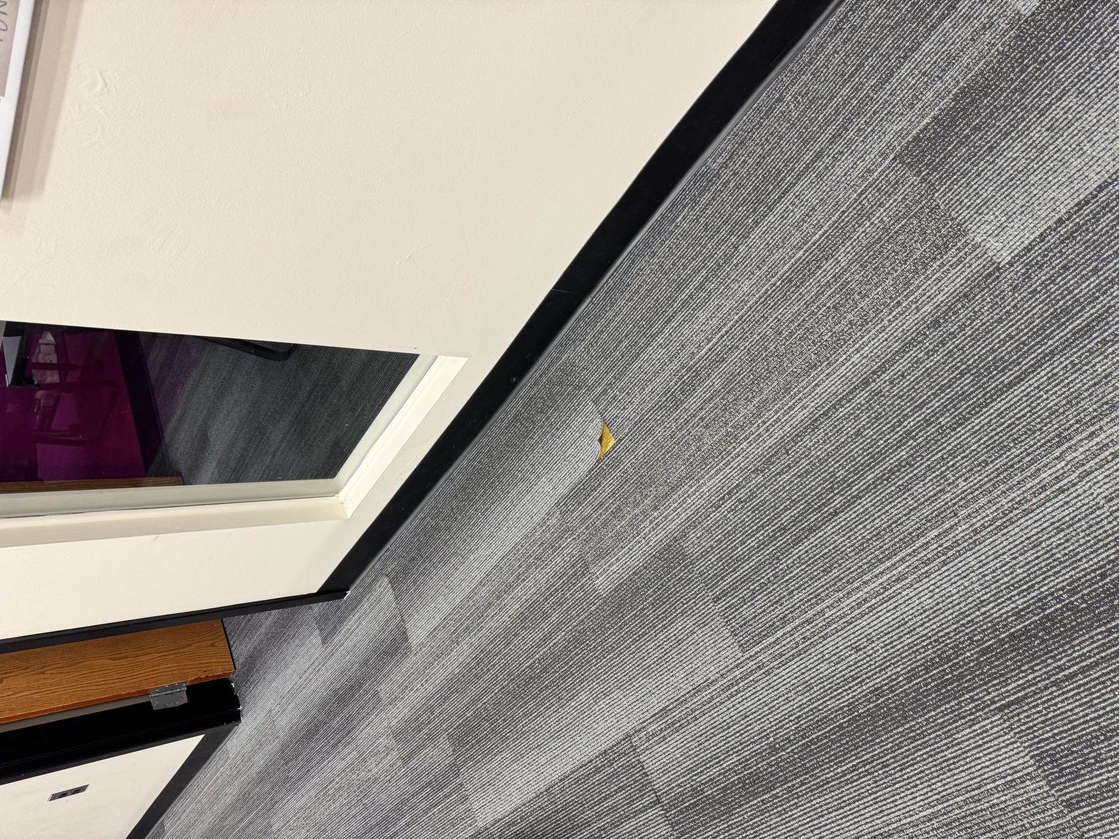 Open seam and backing separation in carpet at a transition point